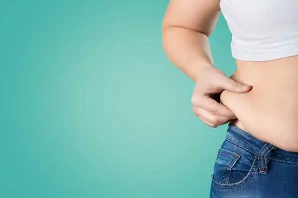 Image of woman pinching her love handles to show weight gain Avonmouth